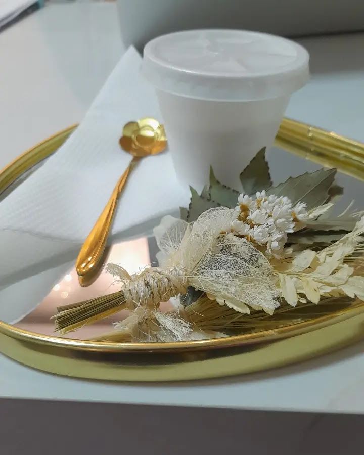 Bandeja dourada com café e flores secas